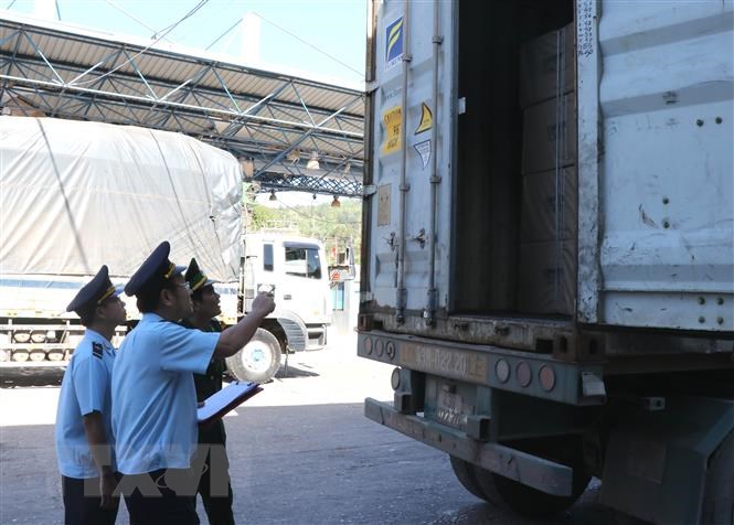 Lực lượng hải quan và biên phòng kiểm tra hàng hóa trên xe Container tại Cửa khẩu Quốc tế Lao Bảo. (Ảnh: Nguyên Lý/TTXVN)